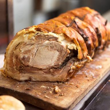 Porchetta, classic Roman street food made with slow-roasted pork seasoned with herbs, served fresh at local markets in Rome