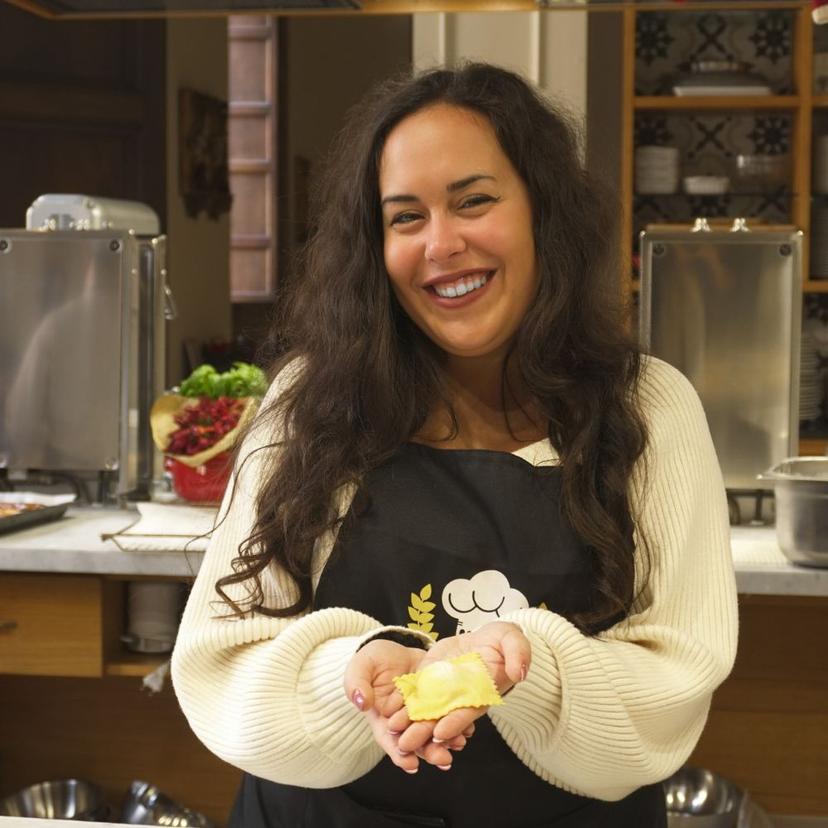 Pasta Making Class in Rome | Fresh Ravioli Experience Guest holding a freshly made ravioli during a pasta making class in Rome at InRome Cooking