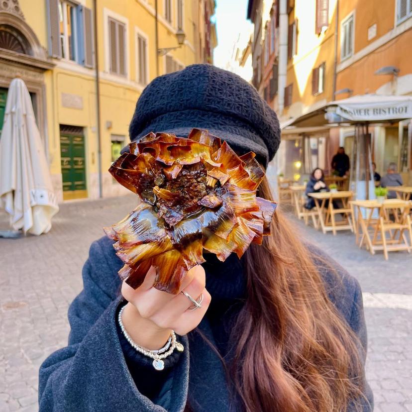 Jewish Ghetto Rome Food Tour | Carciofo alla Giudia Experience Guest holding a traditional Carciofo alla Giudia during a Jewish Ghetto food tour in Rome